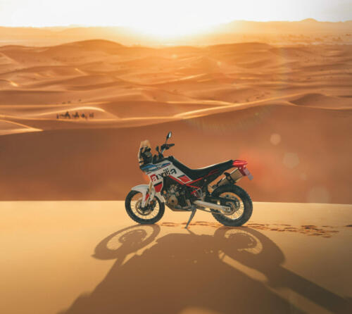Couple walking in Sahara desert at sunset. View from behind, nature background. Travel, freedom and wanderlust concept.